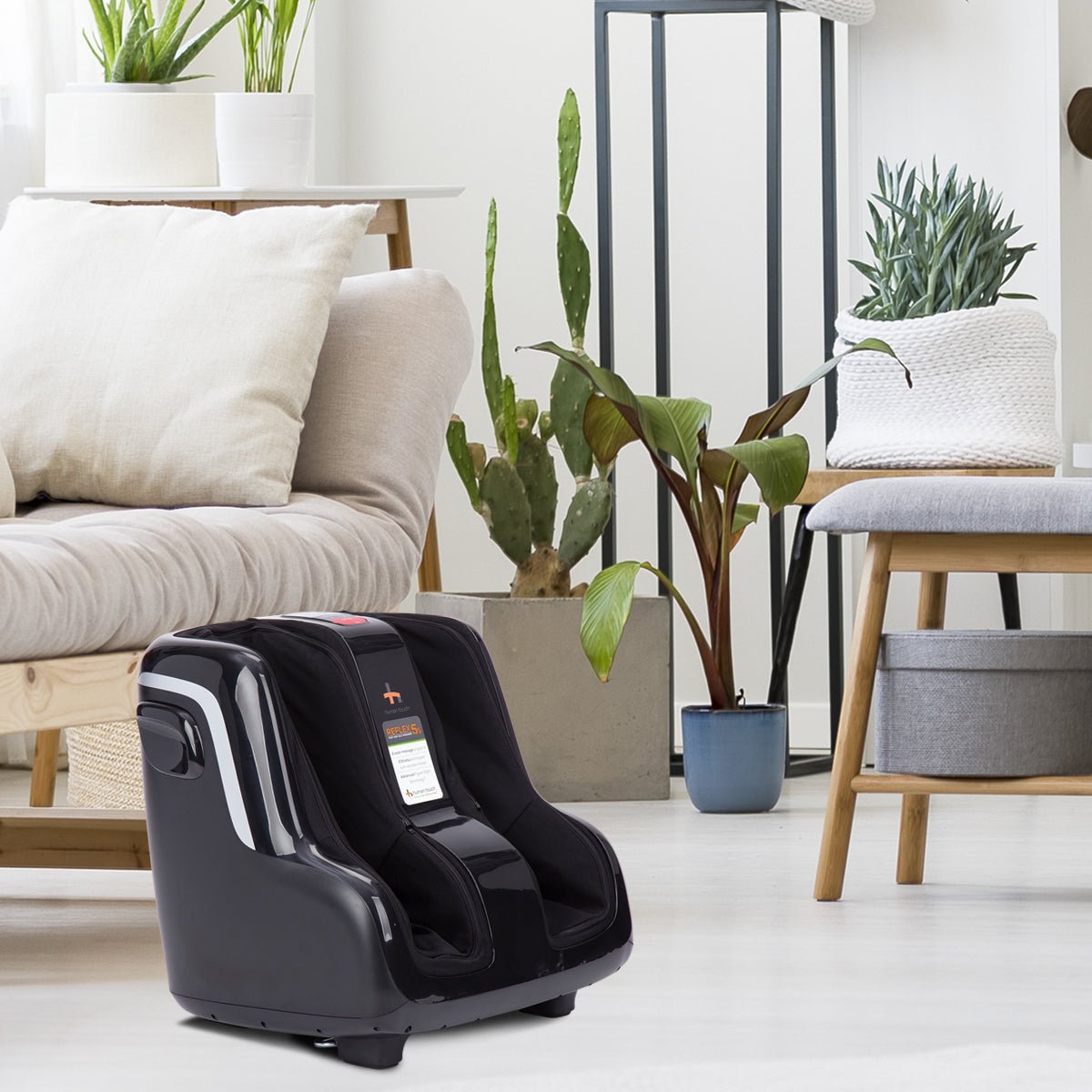 Reflex5s foot and calf massager shown in modern living room with plants and neutral furniture