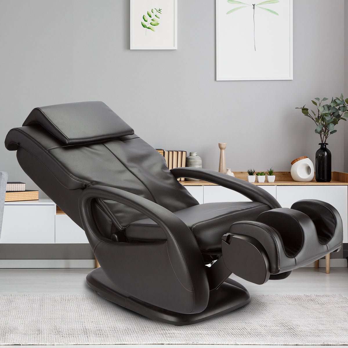WholeBody 7.1 massage chair in black leather, positioned in modern minimalist room with wall art and decorative plants